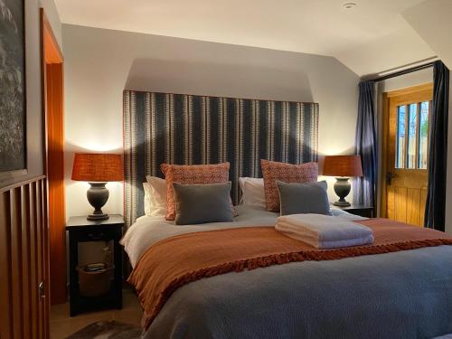 a bedroom with a large bed with two lamps at Pardlestone Farm Cottages in Kilve