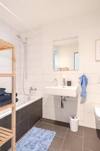 a bathroom with a sink and a tub and a toilet at Im Quer in Neuenhof