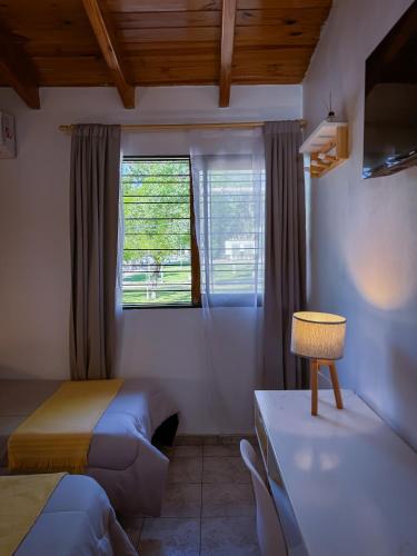 a small room with two beds and a window at Hotel Alta Mendoza in Mendoza