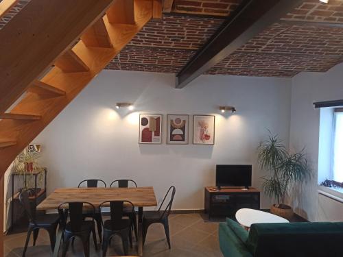 a living room with a wooden table and chairs at Gite La petite cour à Phalempin in Phalempin