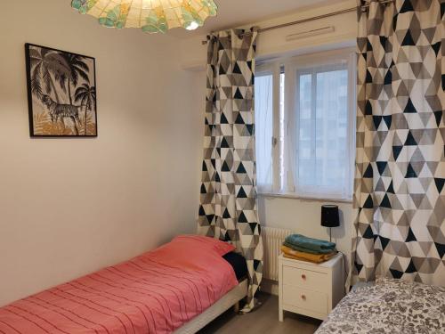 een slaapkamer met een bed en een raam bij Spacieux et lumineux T5 avec 4 chambres, au centre-ville de Mulhouse, grand balcon, grand écran plat in Mulhouse