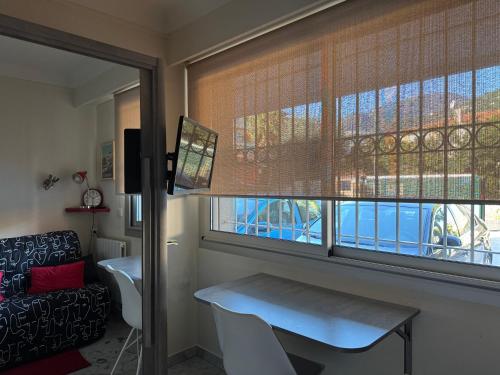 un salon avec une table et une fenêtre dans l'établissement Joli STUDIO Bord de Mer entre Menton et Monaco, à Roquebrune-Cap-Martin