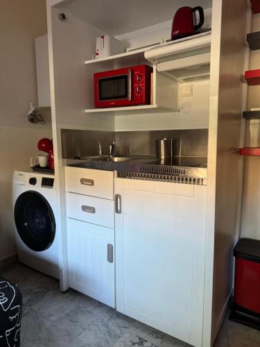une petite cuisine avec un évier et un micro-ondes dans l'établissement Joli STUDIO Bord de Mer entre Menton et Monaco, à Roquebrune-Cap-Martin