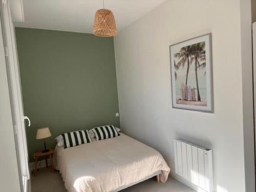 une chambre avec un lit et un tableau au mur dans l'établissement Villa Charlotte, 3 Chambres, Wifi, Terarsse, La Rochelle centre, à La Rochelle