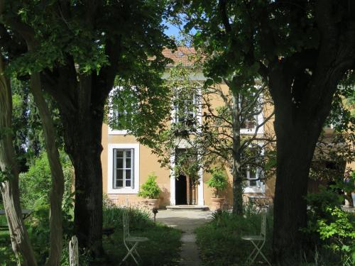 une maison jaune avec des arbres devant elle dans l'établissement La Glacière, ostalarià agricol, à Tresques