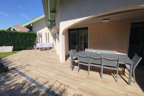 a patio with a table and chairs on a deck at Pretty terraced house with garden level and garage in Aix-les-Bains