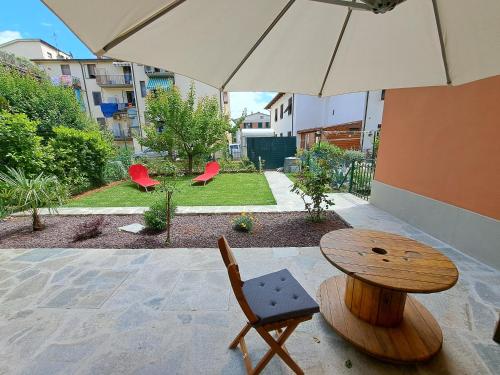 a table and a chair under an umbrella at Appartamento Puccini - Zona Firenze in Le Sieci