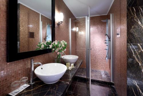 
a bathroom with a toilet, sink and shower at Eurostars Thalia in Prague
