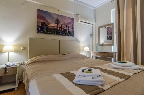 a bedroom with a bed with towels on it at Plaka Studios in Karfas