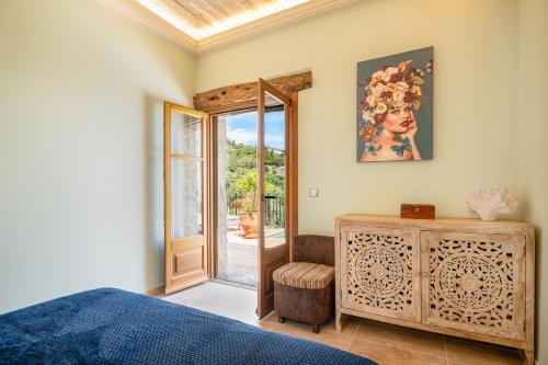a bedroom with a bed and a door to a patio at Bee Tree Villa in Corfu