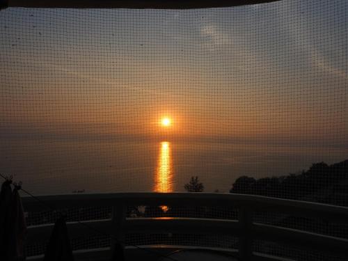 a sunset over the ocean with the sun in the sky at VIP Condochain 345 in Ban Chamrung