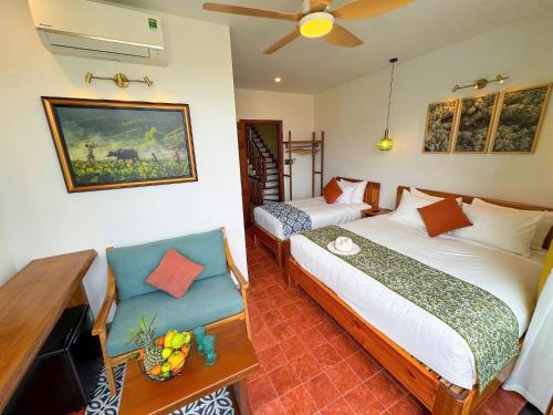 a bedroom with two beds and a ceiling fan at Blue Tropical House Hội An in Hoi An