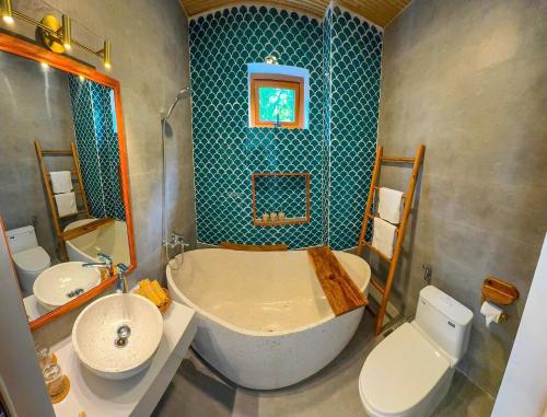 a bathroom with a tub and a toilet and a sink at Blue Tropical House Hội An in Hoi An