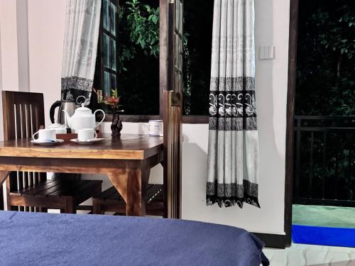 a table with a tea set on it next to a window at sun mount adams peak in Adams Peak