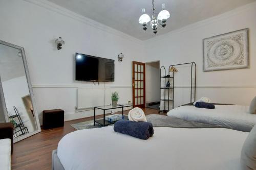 Una habitación con dos camas y un televisor de pantalla plana. en Portsmouth Maisonette with 5 Beds and Pool Table, en Portsmouth