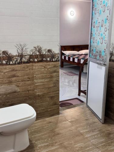 a bathroom with a toilet and a bed at sun mount adams peak in Adams Peak