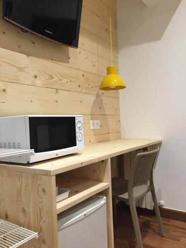 a microwave sitting on top of a wooden desk at Pensión Urkia in Donostia-San Sebastián