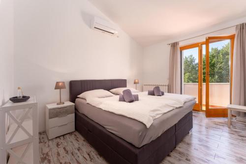 Un dormitorio con una cama grande y una ventana grande. en Villa Emely, en Gradina