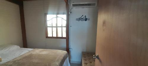 a room with a bed and a door with a window at Cabaña Barbacoas in Santa Ana