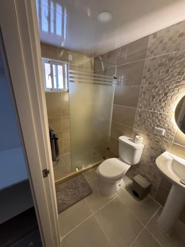 a bathroom with a toilet and a shower and a sink at Modern and Cozy 3-Bedroom Apartment in Santo Domingo in Los Paredones