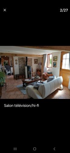 - un salon avec un grand canapé blanc dans l'établissement La p'etit maison rose, à Malouy