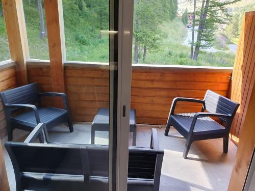 - une véranda avec 2 chaises et une table dans l'établissement Appartement au calme avec vue sur les montagnes à la Foux d'Allos, à Allos