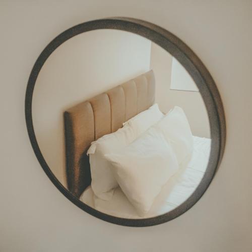 a mirror on a wall with a bed with white pillows at The Black Isle Retreat in Inverness