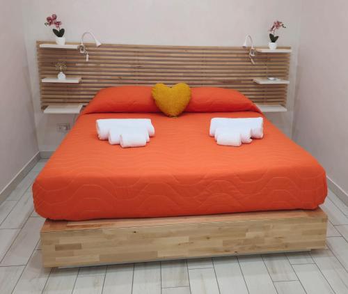 a large orange bed with two pillows on it at Gesuiti Home di Agata e Aurora in Catania