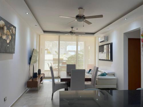 a living room with a dining table and a ceiling fan at Central Luxury Apartment Playa del Carmen in Playa del Carmen