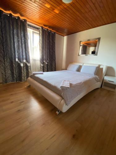 a bedroom with a large bed and a window at Casa Nicollae in Silvaşu de Sus