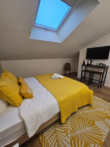 une chambre avec un lit avec une couverture jaune dans l'établissement Chambre Isis, à Sainte-Geneviève-des-Bois