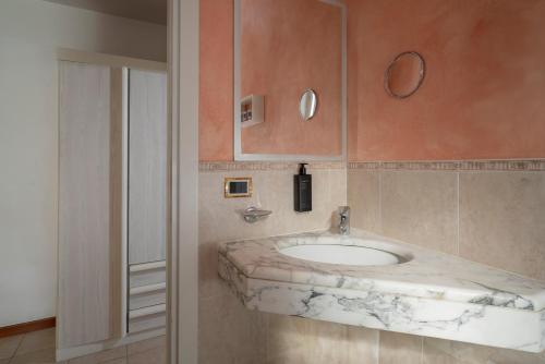 a bathroom with a marble sink and a mirror at Hotel Du Soleil in Rimini