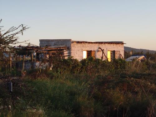 an old house in the middle of a field at Infinity Camp Grounds Maanzoni Backpackers in Kenplains