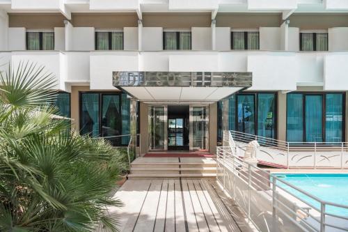 an external view of a building with a swimming pool at Hotel Du Soleil in Rimini