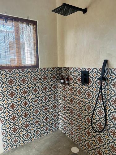 a bathroom with a shower with a tile wall at Hotel Boutique Can Cocal El Cuyo in El Cuyo