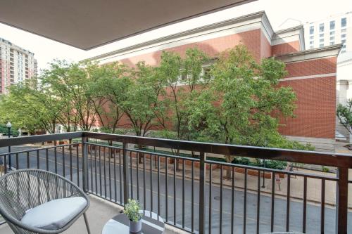 a balcony with a chair and trees and a building at Spacious and Minimalist Apartment w Awesome Facilities in Arlington