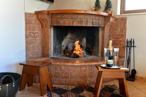 a brick fireplace with a fire in it at Gianna's Guest House in Arachova