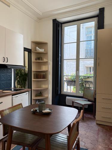 une cuisine et une salle à manger avec une table et une fenêtre dans l'établissement Appartement Rive Gauche, à Paris