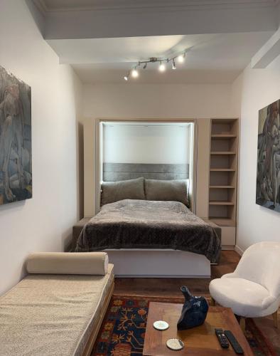 une chambre avec un grand lit et une chaise dans l'établissement Appartement Rive Gauche, à Paris