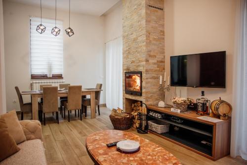 a living room with a television and a dining room at Apartmani Jela Zlatar in Vukovina