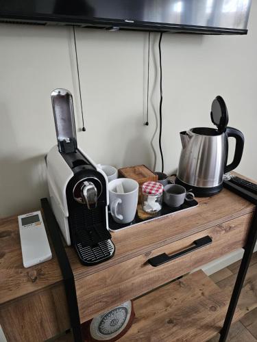 - une cafetière et des tasses sur une table en bois dans l'établissement Chambre plume, à Sainte-Geneviève-des-Bois