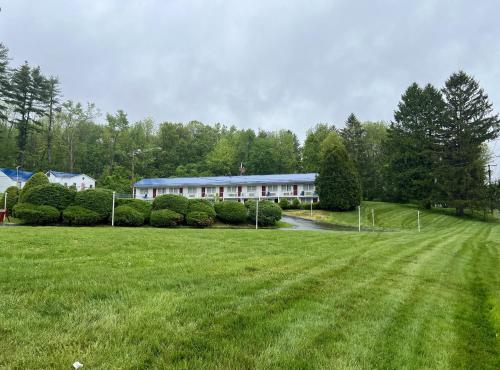 a large grass field in front of a building at Economy Lodge 682 Main St Sturbridge in Sturbridge