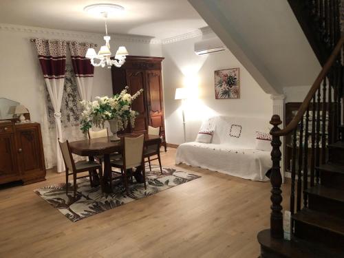Una sala de estar con una mesa y una cama. en La Maison Marguerite, en Herrère