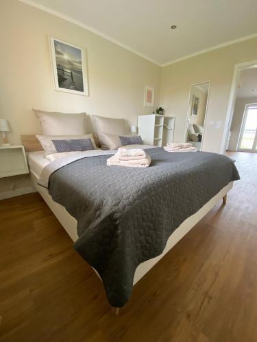 a bedroom with a large bed with two towels on it at Ferienwohnung Watt'n Ausblick in Simonsberg