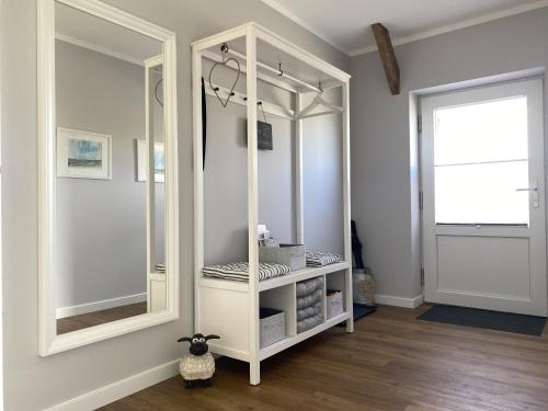 a white cabinet with a mirror in a room at Ferienwohnung Watt'n Ausblick in Simonsberg