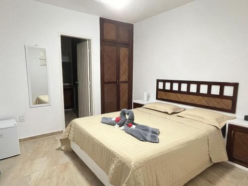 a bedroom with a bed with a stuffed animal on it at Praia Marina Suite - Morro Branco in Beberibe