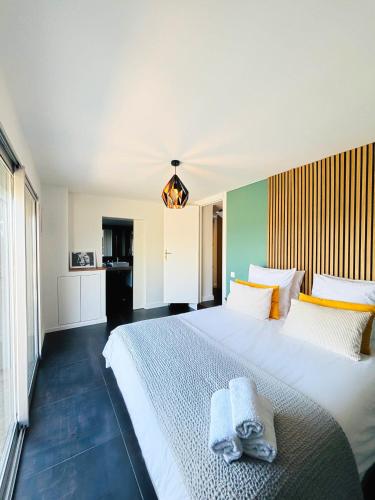 une chambre avec un grand lit blanc avec des serviettes dessus dans l'établissement Superbe Villa vue Mer Époustouflante proche Cannes, à Mandelieu-la-Napoule