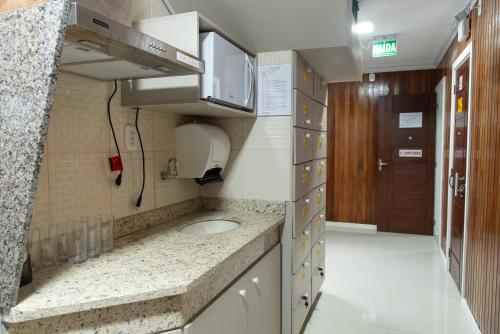 a small kitchen with a sink in a room at Dalmo Hotel in Gravatal