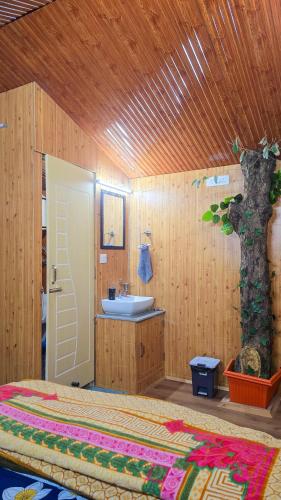 a bathroom with a bed and a sink and a tree at TREE HOUSE BY THE CITY ESCAPE in Shimla