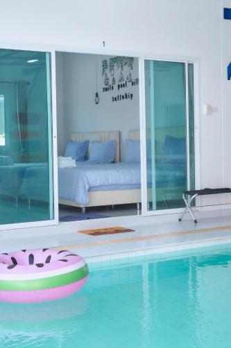 a room with a pool with a bed and a couch at 91 Smile Pool Villa Sattahip in Ban Tao Than